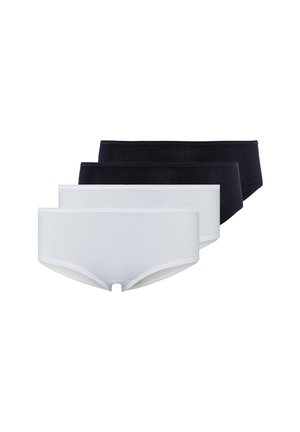 Femme portant un soutien-gorge noir et un slip boyshort noir, debout sur fond blanc.