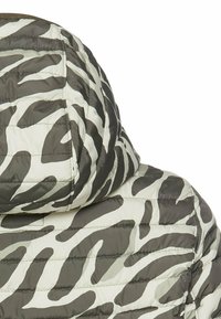 Padded jacket z kapturem, który ma szary i biały wzór w zebry. Wypełniony materiał z pikowanym wzorem i kontrastowym ściegiem wzdłuż szwów.