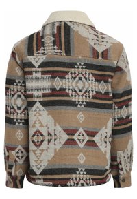 Bruine en beige gestreepte jas met geometrische ontwerpen. Heeft een zachte, sherpa kraag en knoopmanchetten. Gemaakt van een gestructureerde stof.