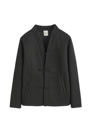 Veste matelassée noire à manches longues, deux poches avant et fermeture à bascule devant, sans col.