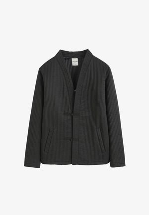 Veste matelassée noire à manches longues, deux poches avant et fermeture à bascule devant, sans col.