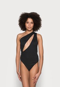 Costume da bagno intero nero con un design asimmetrico e un dettaglio di design ritagliato sul lato, realizzato in tessuto liscio e texturizzato.