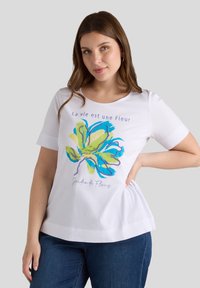 Biała koszulka z krótkim rękawem z kolorowym wzorem kwiatowym oraz napisem "La vie est une Fleur" i "Jardin de Fleurs."