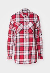 Chemise en flanelle à carreaux rouges et noirs avec des manches longues, deux poches poitrines, fermeture à boutons et un design de col classique.