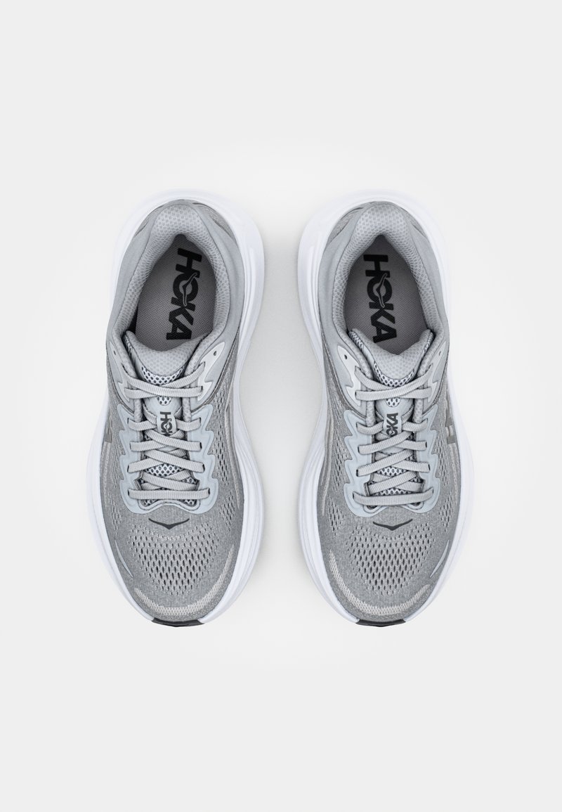 Gray athletic shoes featuring a mesh upper, textured design, flat laces, and a cushioned white midsole and outsole. Logo visible on the side.