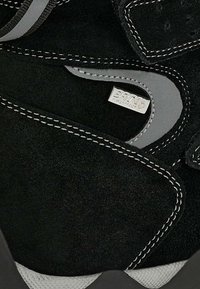 Czarno-szare zamszowe buty ochronne z wzmocnionymi szwami, metalową metką "BRKA" oraz teksturowaną, antypoślizgową podeszwą.