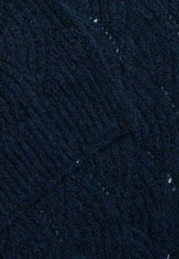 Tessuto a maglia blu scuro con un motivo a cable in rilievo e macchie bianche sparse qua e là per un effetto materico. Aspetto morbido e simile alla lana.