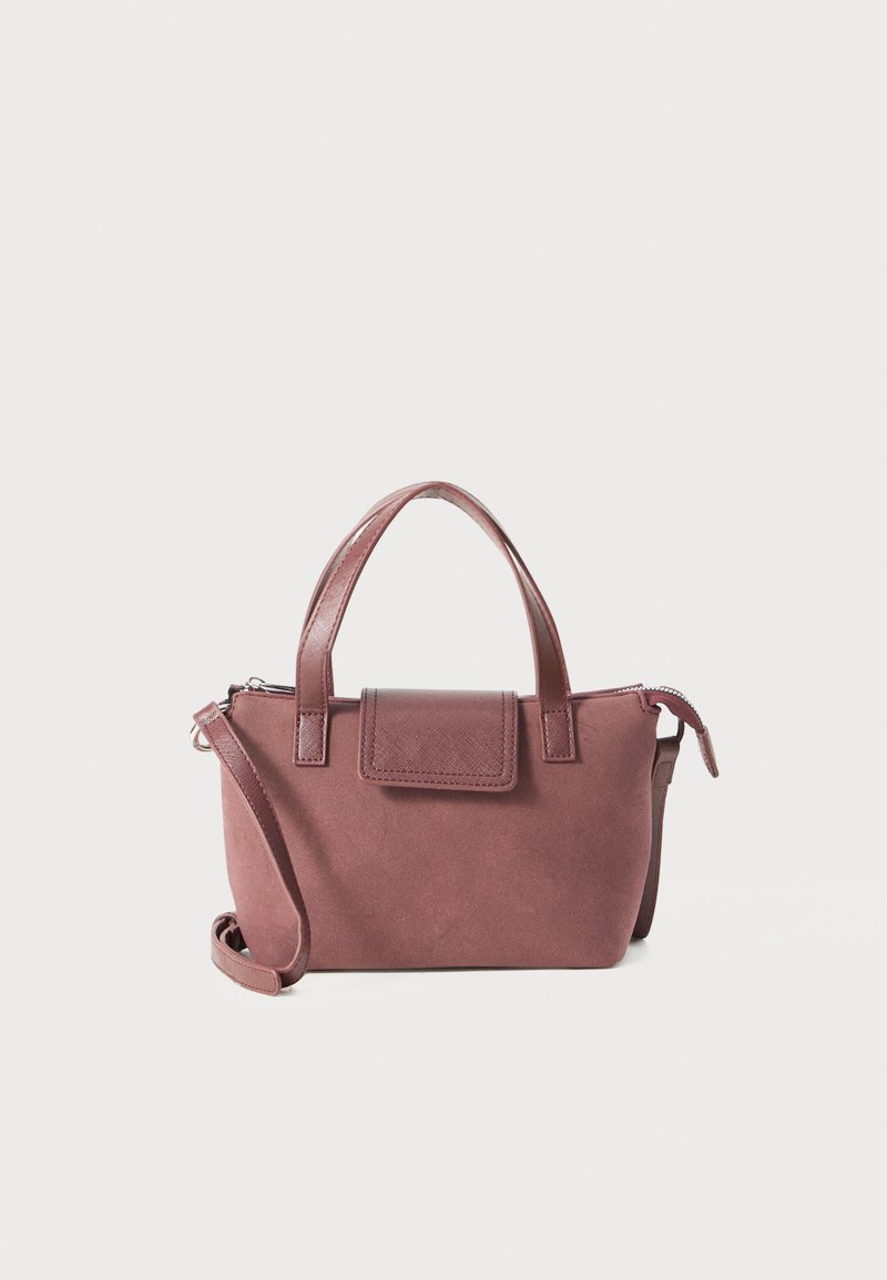 Small mauve handbag with top handles, a front flap detail, and an adjustable shoulder strap against a plain white background.