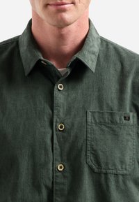 Groene overhemd met knopen, gemaakt van textuurstof, met een kraag, een borstzak en lichte knopen. Eenvoudig ontwerp met minimale details.