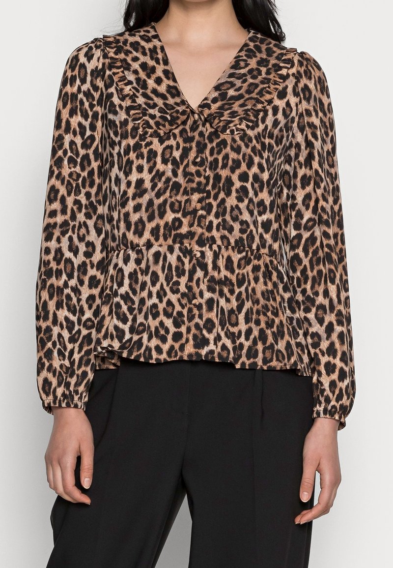 Blůza s leopardím potiskem, s volánkovým límečkem, dlouhými rukávy a sklady na spodním lemu. Tkanina je hladká a lehká, s hnědo-černou barevnou kombinací.