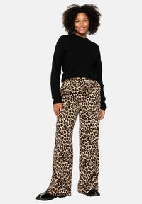 Leopard print wide-leg trousers with a high waistband, paired with a black sweater. Smooth fabric, relaxed fit, and subtle texture.