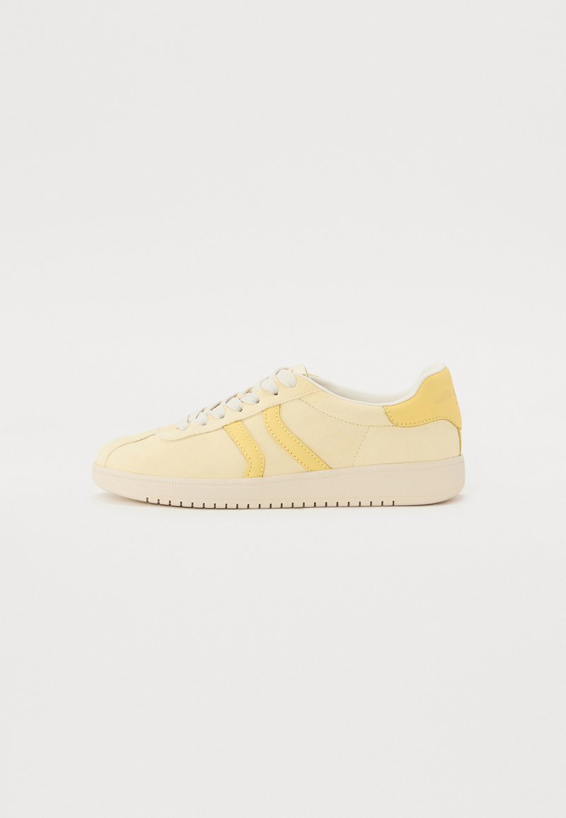 Gelbe Sneaker mit Obermaterial aus Wildleder und Leder, ausgestattet mit einer glatten Oberfläche, weißen Schnürsenkeln und einer Gummisohle mit strukturierten Akzenten.