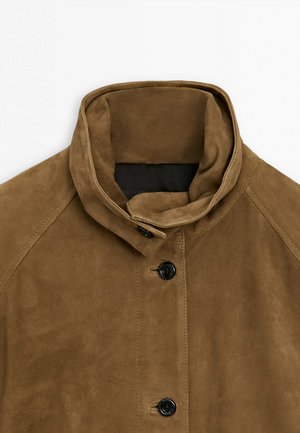 Hnědá semišová bunda s vysokým límcem a černými knoflíky, zobrazena od ramen vzhůru na bílém pozadí.