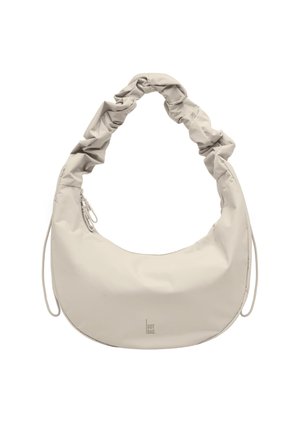 Bolso beige en forma de media luna con asa fruncida y detalles de cordón sobre fondo blanco.