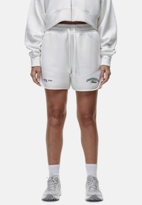 Witte katoenen shorts met een trekkoord in de taille, voorzien van groene tekst en logo's. Soepele textuur, relaxed fit, knielang ontwerp.