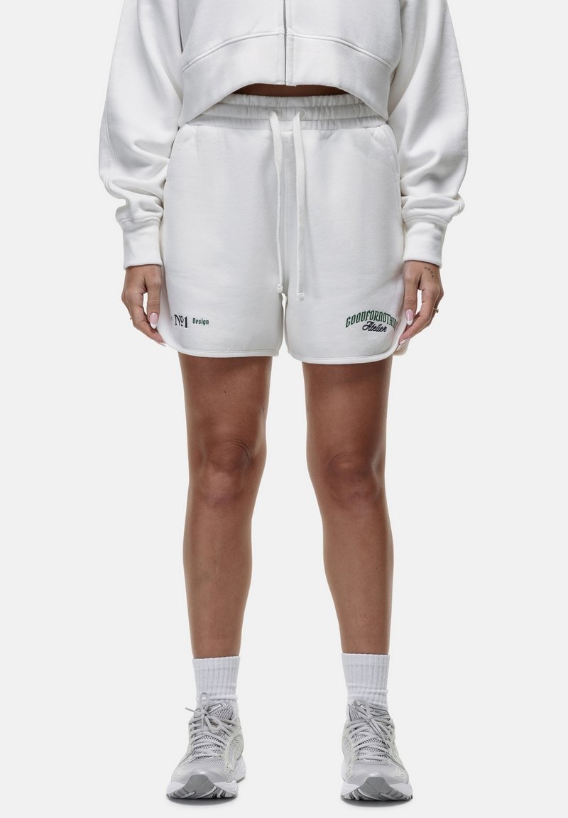 Witte katoenen shorts met een trekkoord in de taille, voorzien van groene tekst en logo's. Soepele textuur, relaxed fit, knielang ontwerp.