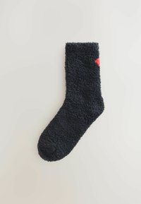 Mørkeblå fuzzy sok med en fyldig tekstur; har et lille rødt hjerteaccent nær toppen. Rund tå og ribbet kant.