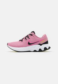 Scarpe da ginnastica rosa con tessuto a rete, lacci neri e una suola intermedia bianca arrotondata. Dotate di uno swoosh Nike nero e dettagli gialli sul tallone.