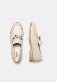 Beige læder loafers med en kædedetalje på vamps, der har en lav stablet hæl og en struktureret gummisål. Glat finish med diskret syning.