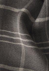 Tissu à carreaux gris présentant une texture douce avec des lignes blanches et un subtil motif tissé, créant une apparence chaleureuse et confortable.