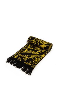 Sciarpa lavorata a maglia con un design a motivo giallo e nero, con bordo frangiato, arrotolata a un'estremità. Il materiale appare morbido e texturizzato.
