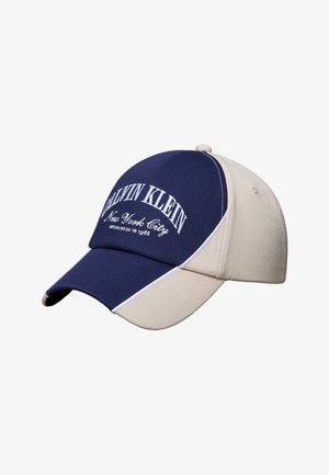 Șapcă de baseball bicoloră, bleumarin și bej, cu text alb "Calvin Klein New York City" brodat pe panoul din față.
