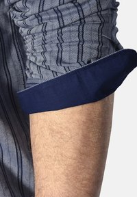 Blau-weiß gestreifter Hemdsärmel mit gerafftem Stofftextur, ausgestattet mit einem einfarbigen dunkelblauen Bündchen und feinem Fischgrätmuster.