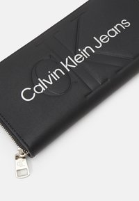 Calvin Klein Jeans SCULPTED ZIP AROUND MONO - Lommebok - black
