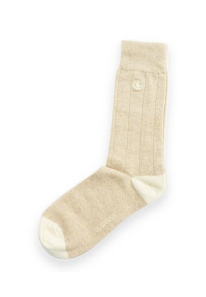 Calcetín beige con canalé con punta y talón blancos, parte superior con puño y un pequeño logo circular cerca del lateral superior.