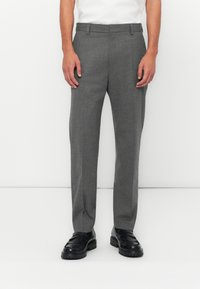 Gray tailored trousers made of textured fabric, featuring a straight-leg design, belt loops, and side pockets, paired with black loafers.