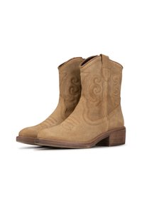 Botas de cowboy de ante en color marrón claro con acentos curvados y detalles de costura. Punta ligeramente puntiaguda, lengüetas para facilitar el calzado y un tacón de madera apilada.