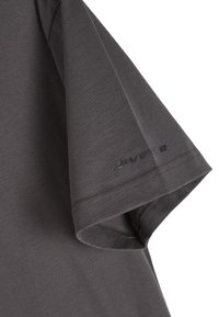 Szara koszulka, krótki rękaw, o gładkiej bawełnianej teksturze. Posiada przeszyty dół i subtelne logo blisko rękawa.