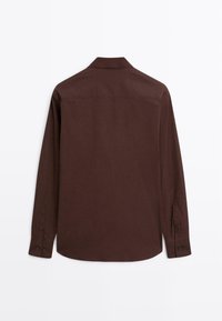 Brun langærmet skjorte med krave, knapmanchetter og en glat tekstur. Simpelt design uden synlige mønstre eller accenter.