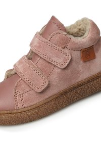 Růžová semišová vysoká bota s suchým zipem, měkkou podšívkou a strukturovanou hnědou gumovou podrážkou. Na boku se nachází kruhové logo.