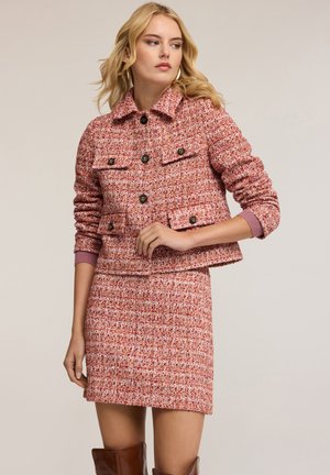 Rode tweed jasje met een kraaglijn en knoopsluitingen, gecombineerd met een bijpassende rok, met textuurpatronen en een getailleerd ontwerp.