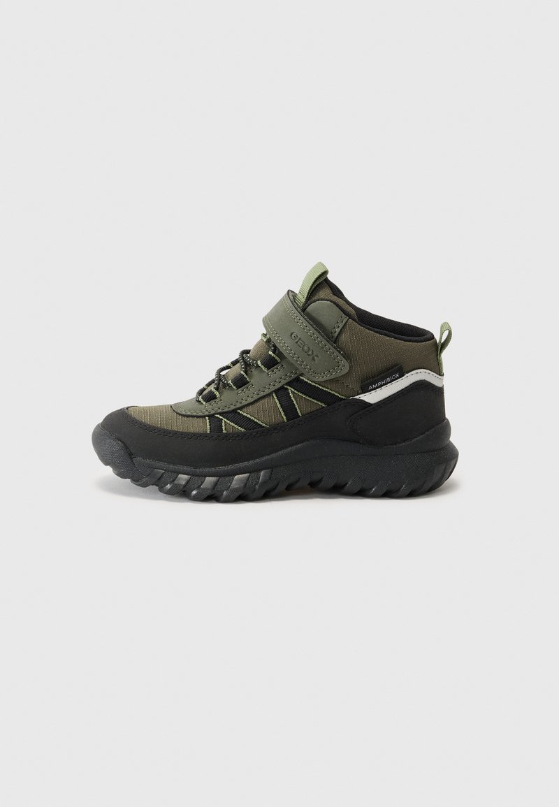 Chaussures de randonnée vertes et noires avec un design montante, tissu texturé, sangle Velcro et semelle en caoutchouc robuste pour une bonne adhérence.