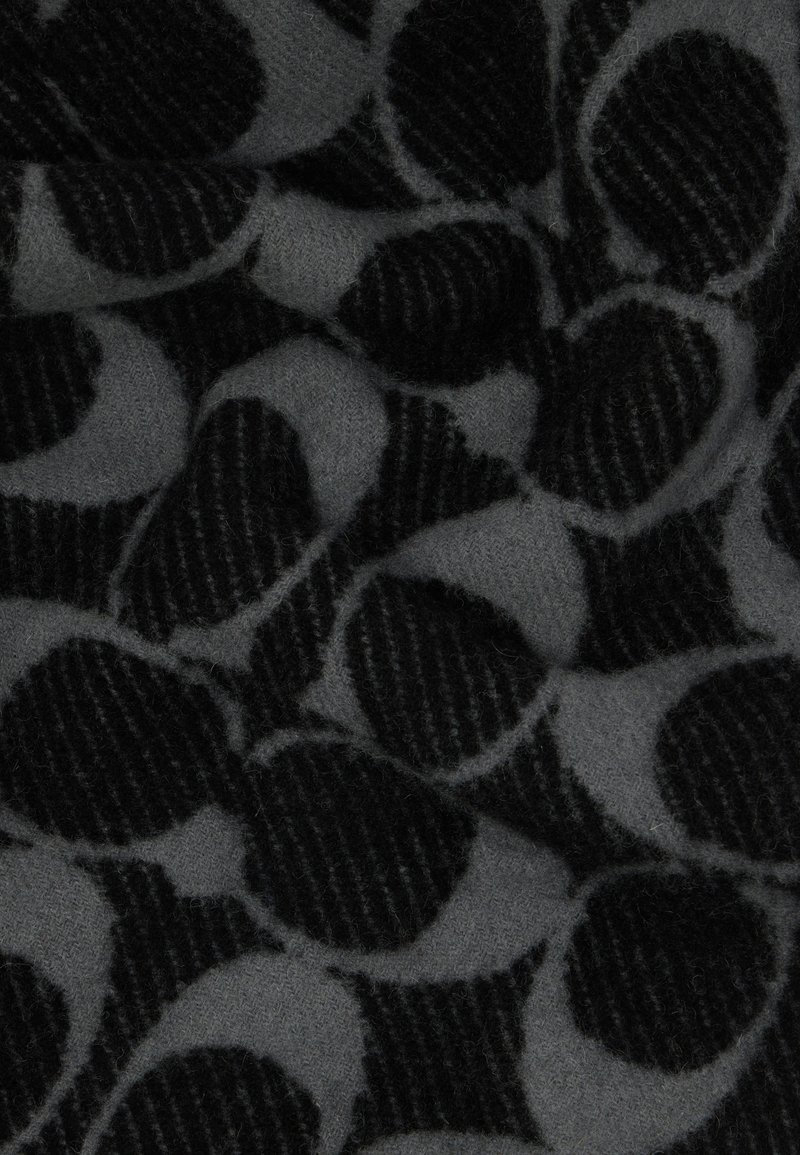 Wolweefsel met een grijze achtergrond, grote zwarte stippen en getextureerde zwarte strepen, wat een gelaagd patroon effect creëert.