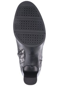Suela de zapato de cuero negro con un patrón de cocodrilo en relieve. Presenta caucho texturizado para agarre y un tacón redondeado para estabilidad.
