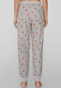 Grijze pyjamabroek met een patroon van cartoonhonden die kerstmannenhoedjes dragen. Elastische tailleband en omgeslagen broekspijpen. Zacht, lichtgewicht stof.