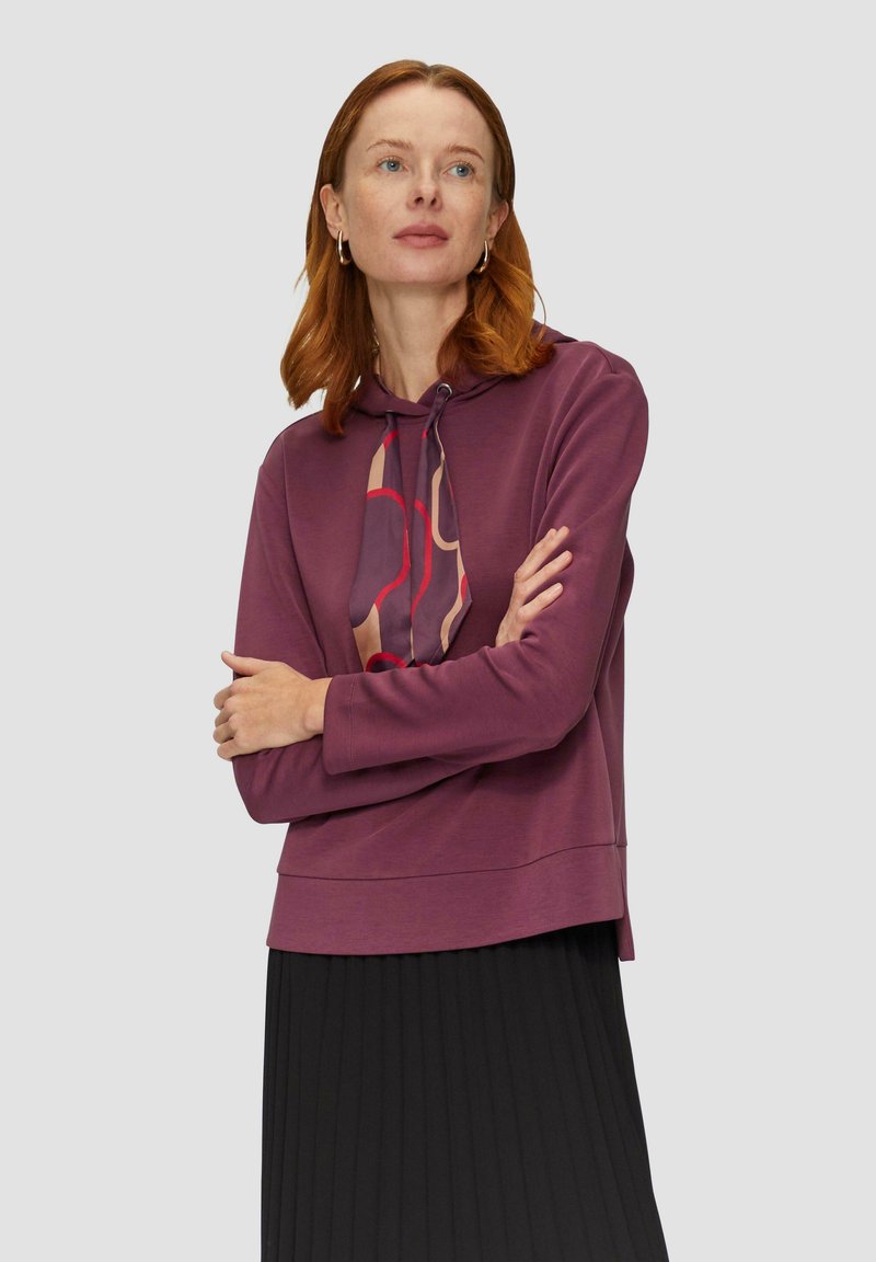 Bordeaux hoodie met een gestreepte koord, lange mouwen en een relaxte pasvorm, gecombineerd met een zwarte plissérok. Zachte textuur.