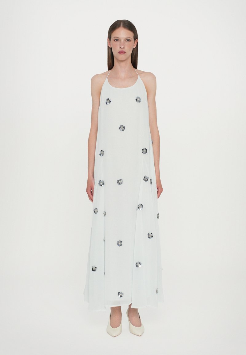 Vestido maxi sin mangas de color azul claro con adornos florales, tejido fluido y una silueta relajada. Textura suave, diseño en capas.