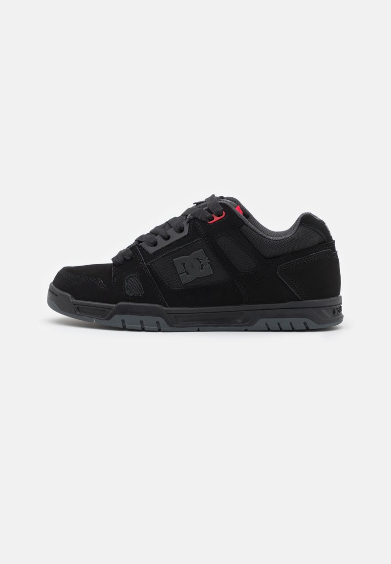 Pantofi de skateboard negri cu un superior din suede și material sintetic. Prezintă panouri din plasă, sireturi plate, talpă din cauciuc și un logo pe lateral.