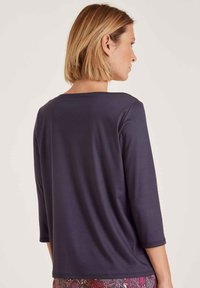 Donkerblauwe lange mouwen top met een ronde halslijn en een ontspannen pasvorm, met een gladde textuur en halflange mouwen. Geen zichtbare patronen of accenten.