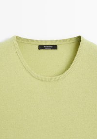 Maglione in maglia verde chiaro con scollo rotondo. Presenta una texture morbida e dettagli a costine lungo il collo. Etichetta visibile all'interno.