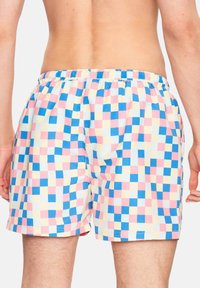 Bañador multicolor con un patrón de cuadros en rosa, azul y amarillo. Cintura elástica y tela suave y ligera.