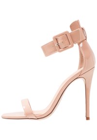 Nude kiiltävä nahka stiletto-sandaali ohuella nilkkaremmin ja neliön muotoisella soljella. Avoin varvasmuotoilu ja sileä, kiiltävä pinta.