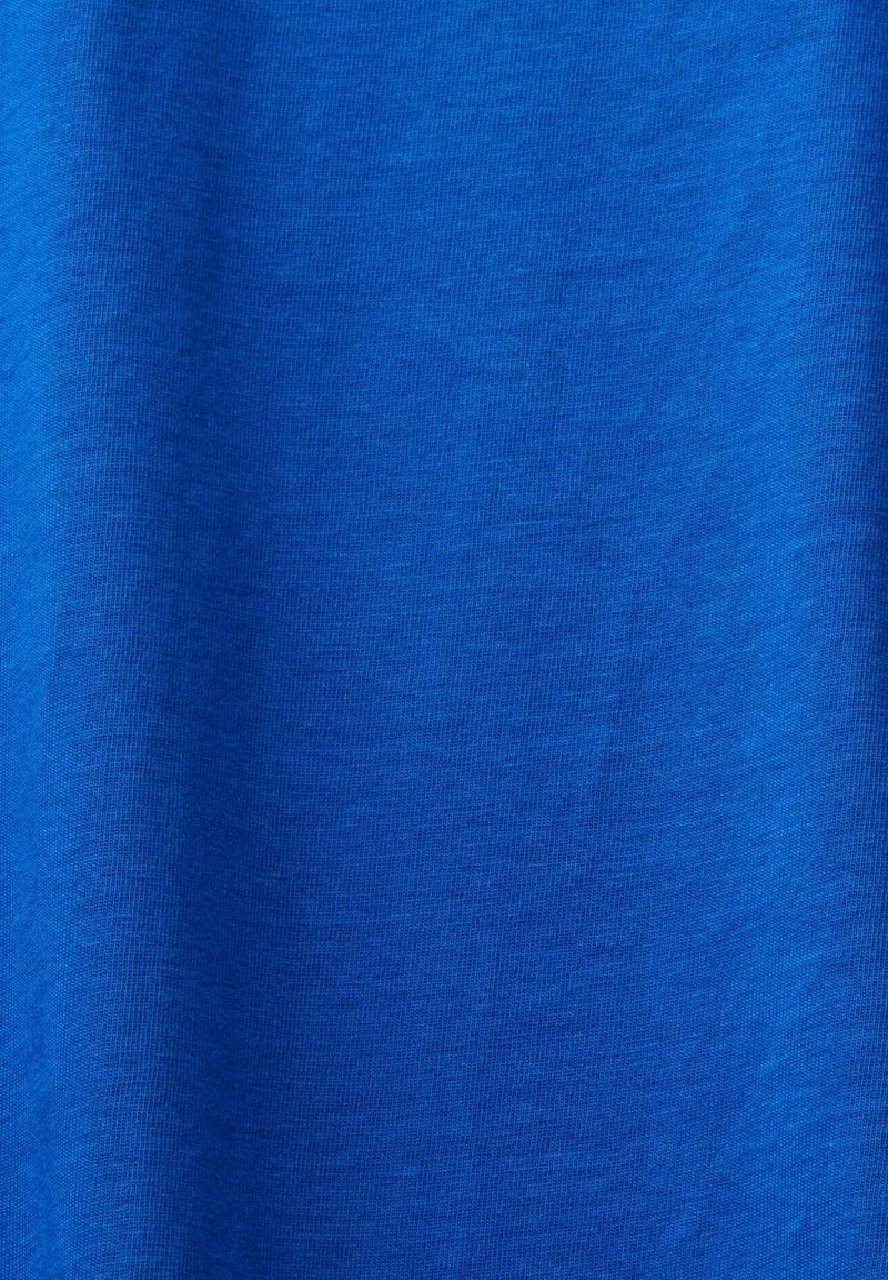 Blått tyg med en mjuk, något strukturerad väv och subtila veck som skapar lätta veck och skuggor.