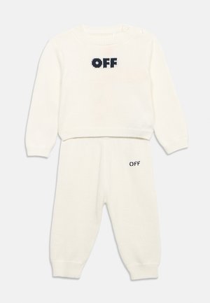Σετ από κρεμ χρώματος μακρυμάνικη πλεκτή μπλούζα και παντελόνι με μαύρη επιγραφή "OFF" στο στήθος και κοντά στην αριστερή τσέπη.