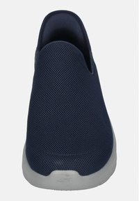 Navy Mesh Slipper mit abgerundeter Form, strukturiertem Obermaterial und weißer Gummisohle. Besitzt einen niedrigen Absatz für einfaches An- und Ausziehen.