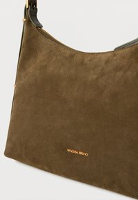 Τσάντα ώμου από σουέτ σε ελαιόχρωμο, με χρυστό φερμουάρ και μικρό λογότυπο "Vanessa Bruno" σε χρυσά γράμματα στο μπροστινό μέρος.